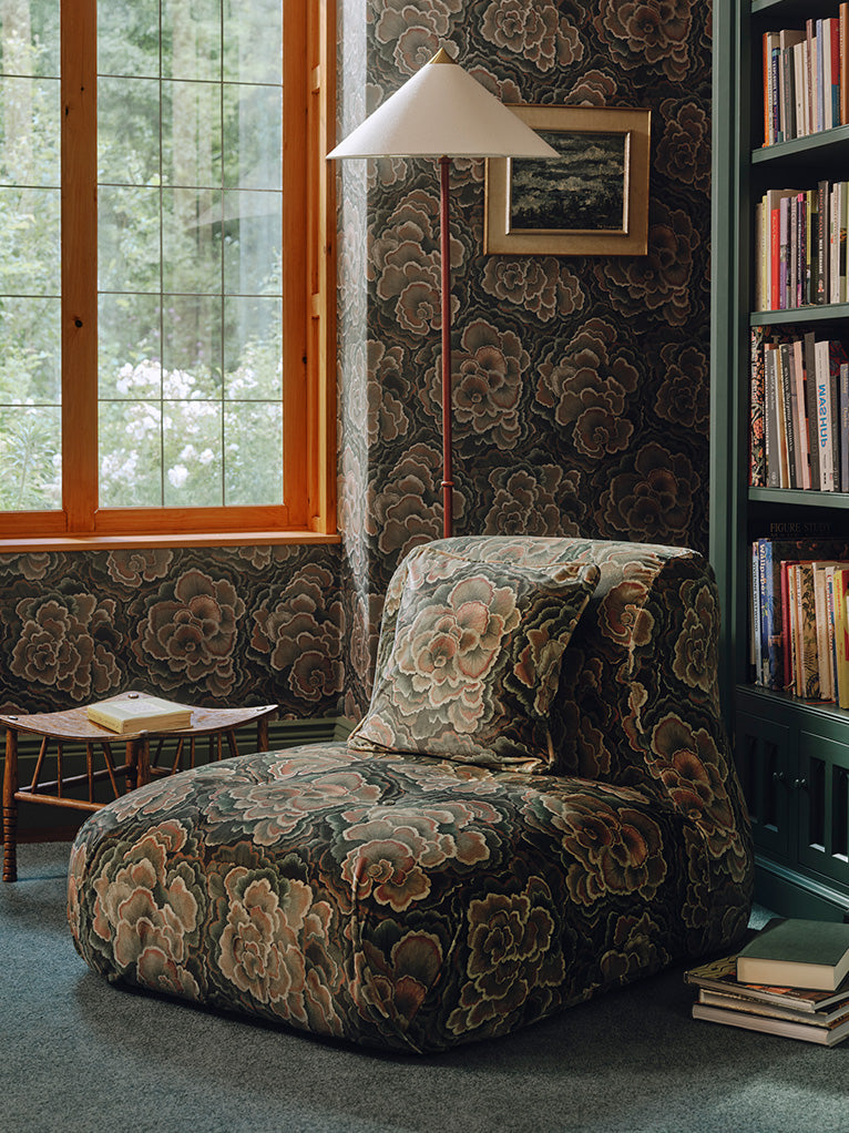 a chair in a room with a bookcase and a window