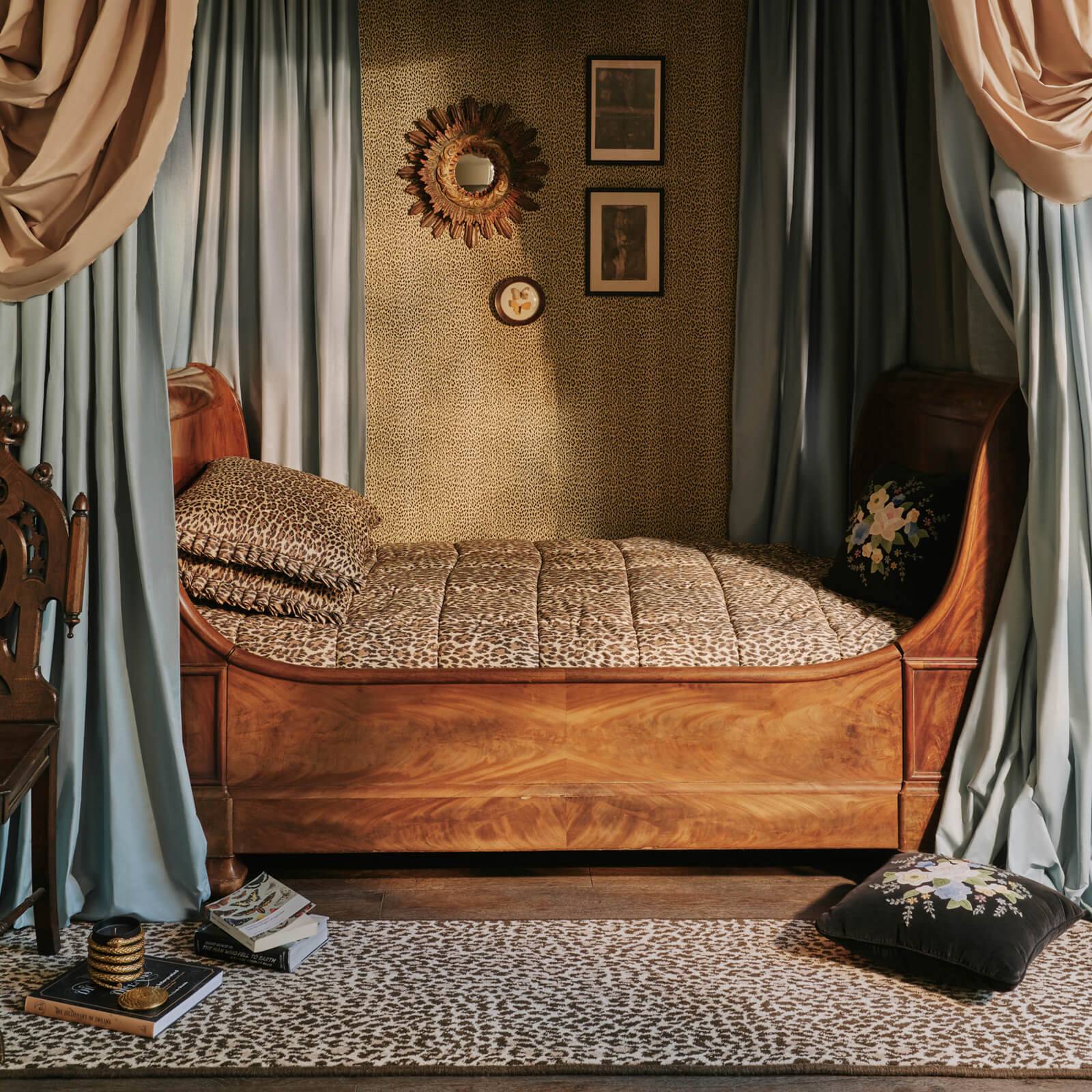 a bed with a leopard print bedding and a chair
