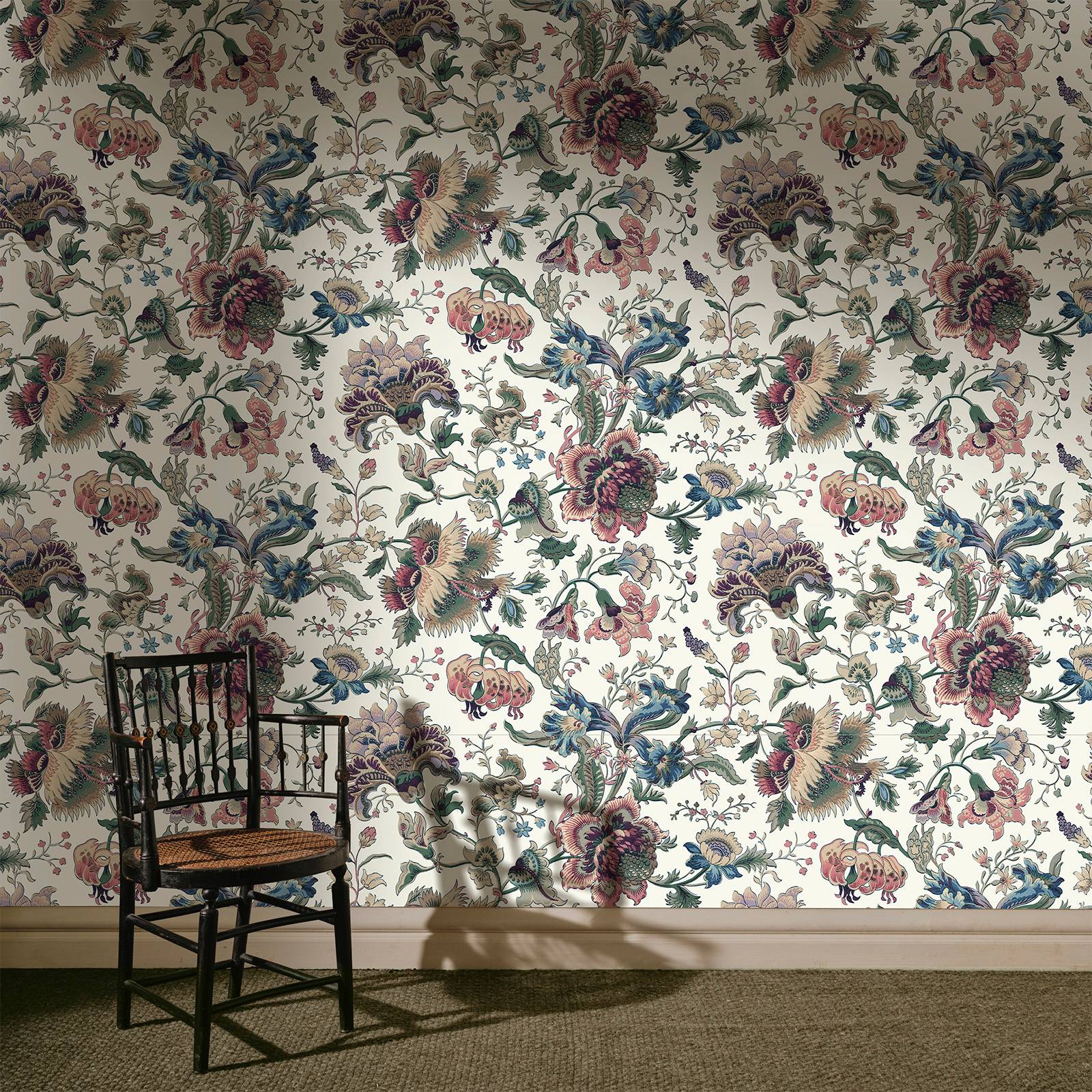 a chair in front of a floral wallpaper