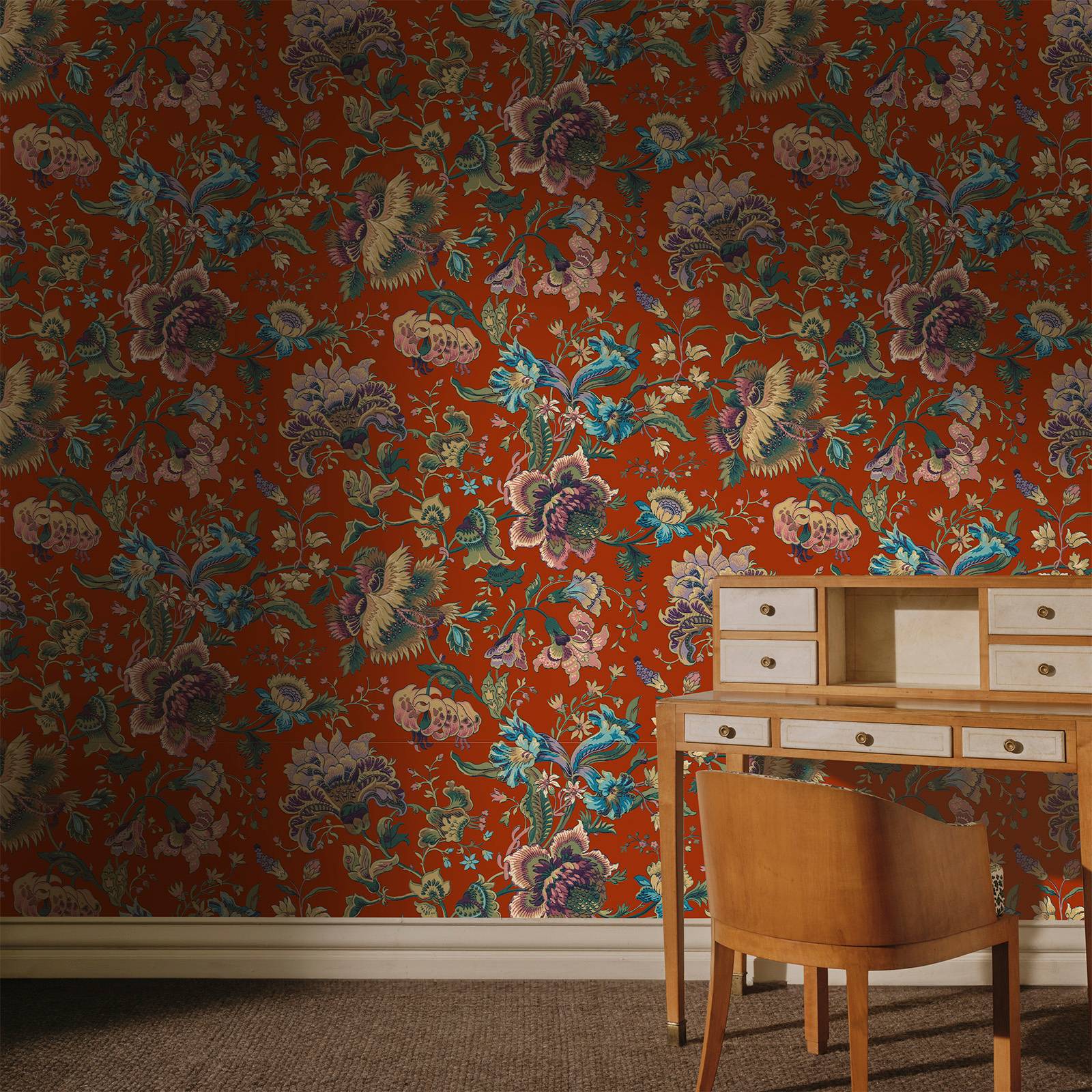 a desk and chair in front of a floral wallpaper